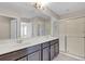 Primary bathroom featuring double sinks, modern fixtures, and a glass-enclosed shower at 1578 Softshell St, St Cloud, FL 34771