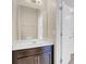 A bright bathroom features a large mirror, a white sink, and a white door at 1578 Softshell St, St Cloud, FL 34771