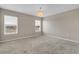 Spacious bedroom with neutral carpet, three windows, and chandelier lighting at 1578 Softshell St, St Cloud, FL 34771