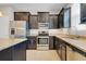 Modern kitchen featuring stainless steel appliances, granite counters, and dark cabinetry at 1578 Softshell St, St Cloud, FL 34771