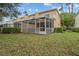 A two-story condo building with a screened-in patio, a lawn, and well-maintained landscaping at 1717 Retreat Cir, Clermont, FL 34714