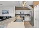 Kitchen showcasing a bar top, stainless steel appliances, and white cabinets, seamlessly blending with living space at 1717 Retreat Cir, Clermont, FL 34714