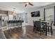 Open-concept living area with an island bar, stainless appliances, and hardwood floors at 1717 Retreat Cir, Clermont, FL 34714