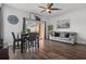 Cozy living room with hardwood floors, a ceiling fan, neutral walls, dining table, and leather sofa at 1717 Retreat Cir, Clermont, FL 34714