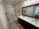Bathroom featuring a double sink vanity, a walk-in shower with glass doors, and neutral tile flooring at 199 Macaulays Cv, Haines City, FL 33844