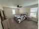 Cozy bedroom with a ceiling fan, carpet, and a comfortable bed with neutral-toned floral patterned bedding at 199 Macaulays Cv, Haines City, FL 33844