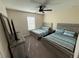 Bedroom features two beds with light wood frames, neutral decor, and a dark ceiling fan at 199 Macaulays Cv, Haines City, FL 33844