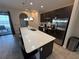 Modern kitchen features a large island with seating, pendant lights, and stainless steel appliances at 199 Macaulays Cv, Haines City, FL 33844