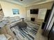 Comfortable living room with a sectional sofa, a modern ceiling fan, and large windows for natural light at 199 Macaulays Cv, Haines City, FL 33844