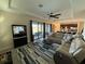 Open living room with a sectional sofa, modern furnishings, and a view of the outdoor pool area at 199 Macaulays Cv, Haines City, FL 33844