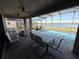 Covered patio features a screened-in pool area with dining and lounge areas, overlooking a picturesque lake at 199 Macaulays Cv, Haines City, FL 33844