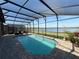 Screened in pool area offers beautiful lake views, blue water, and a brick pool deck at 199 Macaulays Cv, Haines City, FL 33844