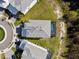 Aerial shot of a modern home with a gray roof, a pool, a green yard, and a circular driveway at 2117 Pine Oak Loop, Davenport, FL 33837