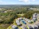 This aerial showcases homes near a wooded area, featuring a pond and mature trees at 2117 Pine Oak Loop, Davenport, FL 33837