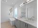 Bright bathroom with double sink vanity, modern bathtub, and decorative wall art at 2117 Pine Oak Loop, Davenport, FL 33837