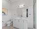 A bright, clean bathroom with a white vanity, a large mirror, and a glass-enclosed shower at 2117 Pine Oak Loop, Davenport, FL 33837
