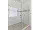 Modern glass enclosed shower featuring white tiled walls and modern fixtures at 2117 Pine Oak Loop, Davenport, FL 33837