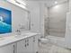 Bright bathroom features a modern vanity and a tiled shower-tub combination at 2117 Pine Oak Loop, Davenport, FL 33837