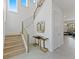 Bright foyer with staircase, modern console table with glass top and metallic gold accents, and tile flooring at 2117 Pine Oak Loop, Davenport, FL 33837