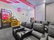 View of the game room with PacMan-themed basketball game, arcade games, and leather theater seating at 2117 Pine Oak Loop, Davenport, FL 33837