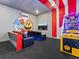 A modern game room with Pac-Personal decor, arcade game, comfortable seating and a TV for entertainment at 2117 Pine Oak Loop, Davenport, FL 33837