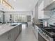 Open concept kitchen featuring stainless appliances, island seating, and view of game and living room at 2117 Pine Oak Loop, Davenport, FL 33837