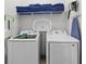 This laundry room features a washer, dryer, shelving with towels, and cleaning supplies at 2117 Pine Oak Loop, Davenport, FL 33837