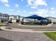 View of the community playground with a blue canopy, modern homes, and well-maintained landscaping at 2117 Pine Oak Loop, Davenport, FL 33837