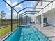 Gorgeous screened-in pool and spa with blue tile and plenty of lounge chairs at 2117 Pine Oak Loop, Davenport, FL 33837