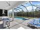 Relaxing screened-in pool with spa, foosball table, outdoor kitchen and plenty of lounge chairs at 2117 Pine Oak Loop, Davenport, FL 33837