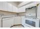 Efficient kitchen design featuring white cabinets, countertops, and appliances at 2210 Yankee Pl # 334, Orlando, FL 32839