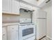 Compact kitchen with white cabinets, stove, refrigerator, and laminate countertops at 2210 Yankee Pl # 334, Orlando, FL 32839