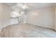 Bright living room with wood floors open to a kitchen with white appliances at 2210 Yankee Pl # 334, Orlando, FL 32839