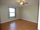 A comfortable bedroom featuring hardwood floors, a ceiling fan, and a window with curtains at 2235 Emperor Dr, Kissimmee, FL 34744