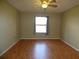 A cozy bedroom featuring hardwood floors, a ceiling fan, and a bright window at 2235 Emperor Dr, Kissimmee, FL 34744