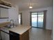 Eat-in kitchen with tile floor features stainless steel sink, breakfast bar, and sliding doors to lanai at 2235 Emperor Dr, Kissimmee, FL 34744