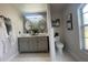 Modern bathroom with double sinks, updated fixtures, decorative mirror and stylish tile flooring at 24 Cordona Dr, Kissimmee, FL 34758