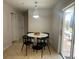 Cozy dining area includes a modern chandelier, slider doors, and seating for four around a marble-topped table at 24 Cordona Dr, Kissimmee, FL 34758