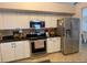 Kitchen features stainless steel appliances, white cabinets, granite countertops, and a stone backsplash at 24 Cordona Dr, Kissimmee, FL 34758