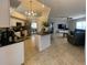 Open floor plan with views into the kitchen and living room, featuring modern lighting and neutral tile floors at 24 Cordona Dr, Kissimmee, FL 34758