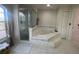 Spa-like main bathroom with a soaking tub, glass-enclosed shower, and elegant tile work at 24 Cordona Dr, Kissimmee, FL 34758