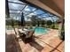 Relaxing screened-in pool with lounge seating and manicured landscaping in the backyard at 24 Cordona Dr, Kissimmee, FL 34758