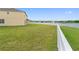 Large backyard with a vinyl fence, a view of the lake, and lush green grass at 2412 Country Pond Ct, St Cloud, FL 34771
