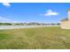 Lush backyard with view of the lake, defined by a white picket fence for privacy and charm at 2412 Country Pond Ct, St Cloud, FL 34771
