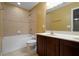 Bathroom with tile floors, a soaking tub with tiled walls, and a wooden vanity at 2412 Country Pond Ct, St Cloud, FL 34771