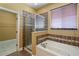 Bathroom with a soaking tub, separate shower, and a window providing natural light at 2412 Country Pond Ct, St Cloud, FL 34771
