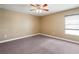 The tan bedroom features a ceiling fan and a window for natural light at 2412 Country Pond Ct, St Cloud, FL 34771