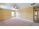 A spacious bedroom with neutral walls and carpet, a ceiling fan, and a window at 2412 Country Pond Ct, St Cloud, FL 34771