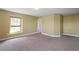 A tan bedroom features a window for natural light and neutral carpeting at 2412 Country Pond Ct, St Cloud, FL 34771