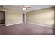 A well-lit bedroom with plush carpet, neutral paint, and a ceiling fan at 2412 Country Pond Ct, St Cloud, FL 34771